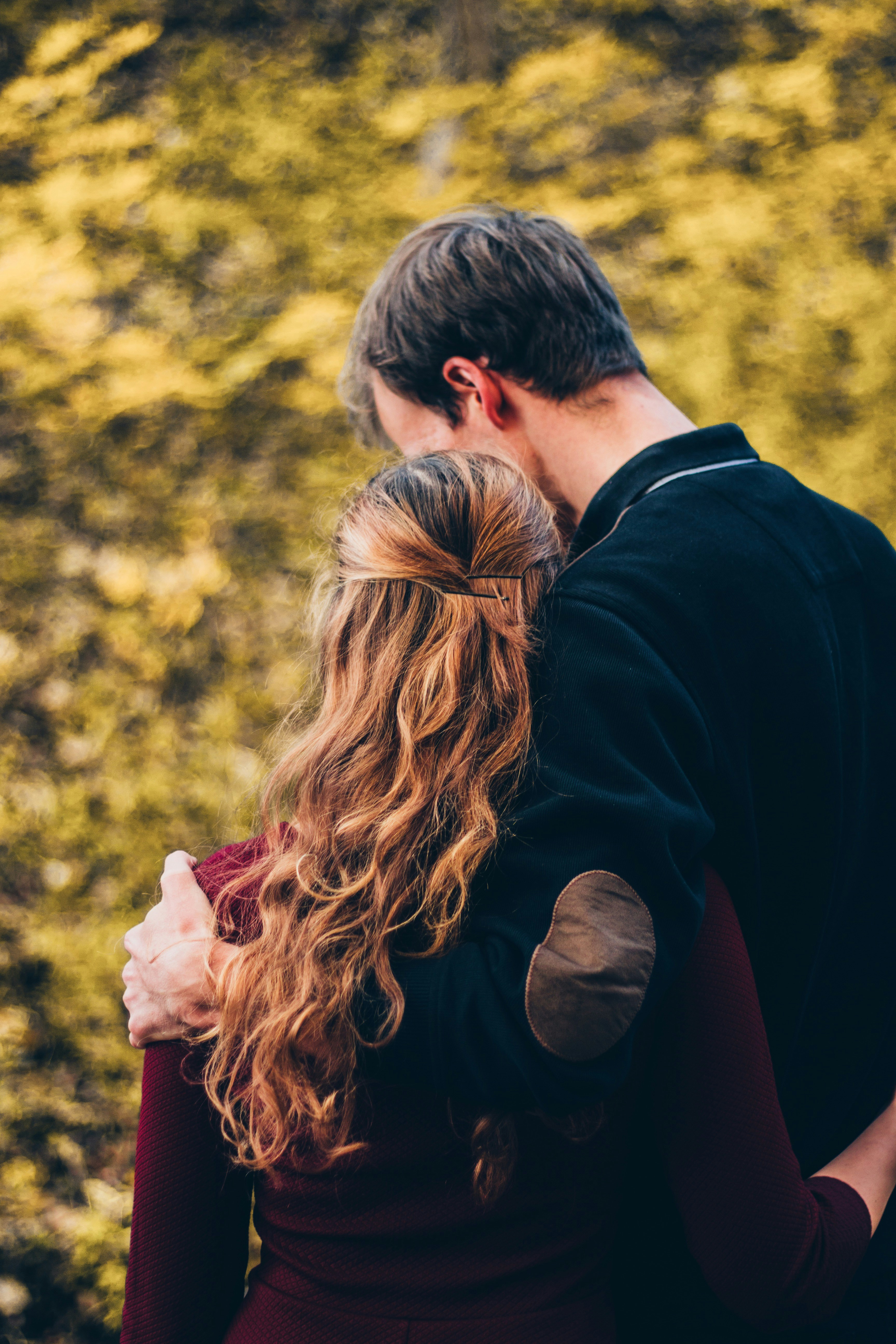 couple standing beside a tree in the daytime